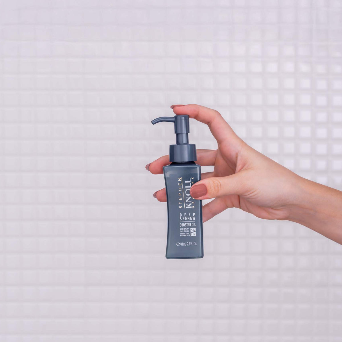 Stephen Knoll Deep & Renew Booster Oil bottle held in hand